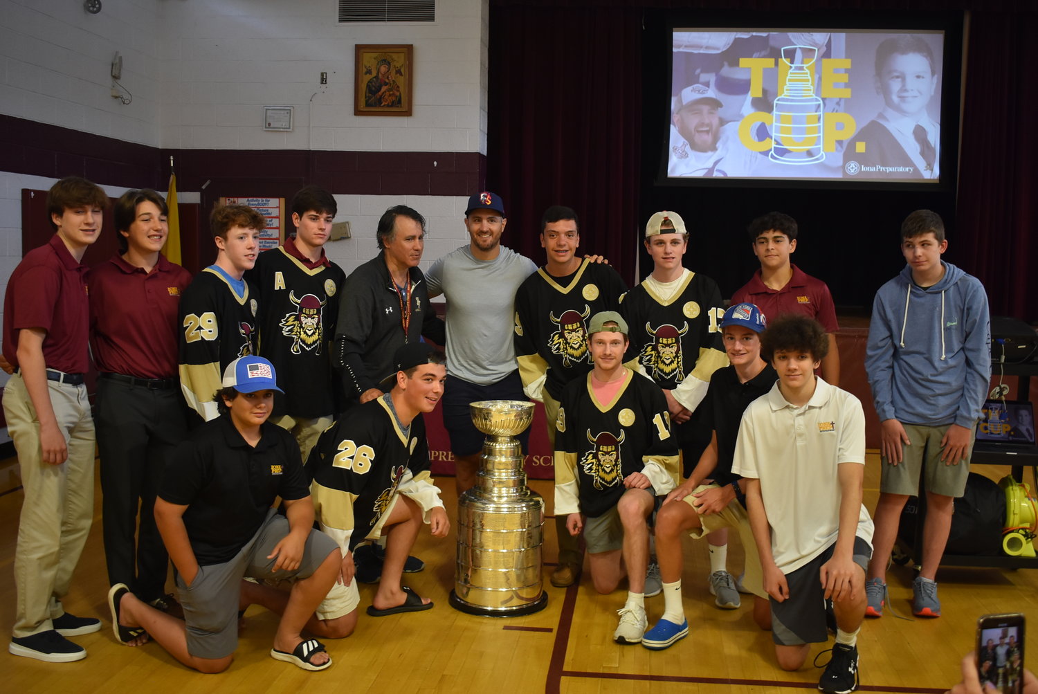 Kevin Shattenkirk, a member of the 2020 Stanley Cup Champion Tampa Bay Lightning, stands in a photo with the Stanley Cup and members of Iona Prep's hockey program at Iona Prep's Lower School on July 17. Shattenkirk is a 2003 graduate of Iona Prep's Lower School.